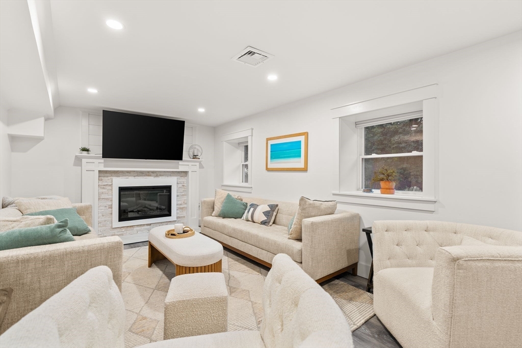 43 Oregon Road Ashland, MA 01721 - Photo 23 of 41 a living room with furniture a flat screen tv and a fireplace