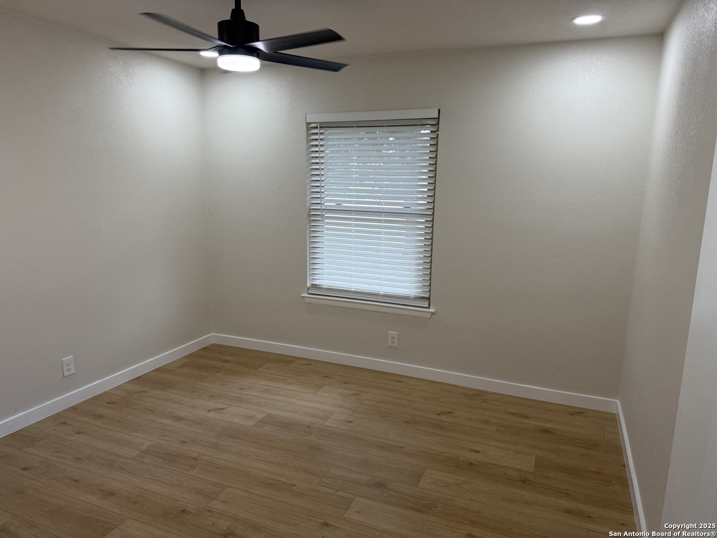 6831 Spring Rose Drive San Antonio, TX 78249 - Photo 11 of 18 an empty room with wooden floor fan and windows
