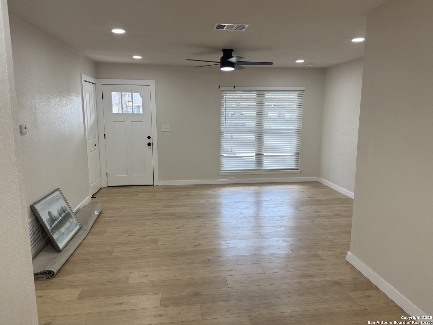 6831 Spring Rose Drive San Antonio, TX 78249 - Photo 4 of 18 an empty room with wooden floor and windows