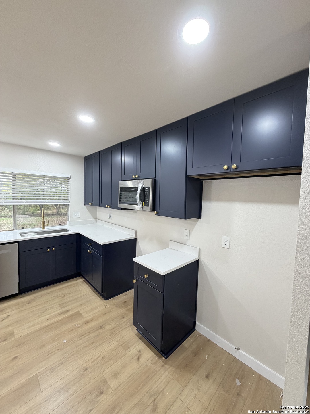 6831 Spring Rose Drive San Antonio, TX 78249 - Photo 6 of 18 a large kitchen with stainless steel appliances kitchen island granite countertop a large counter top and wooden floors