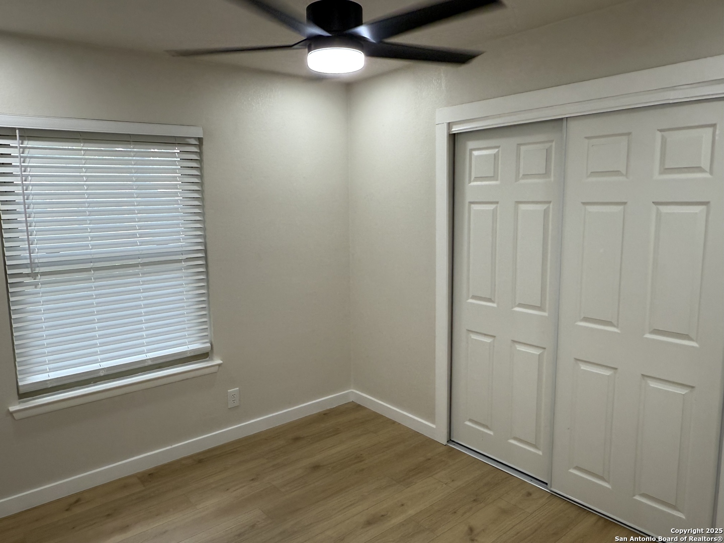 6831 Spring Rose Drive San Antonio, TX 78249 - Photo 10 of 18 an empty room with wooden floor cabinet and windows