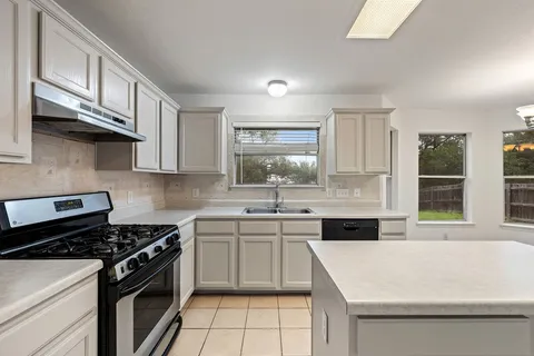a kitchen with stainless steel appliances a sink stove and cabinets
