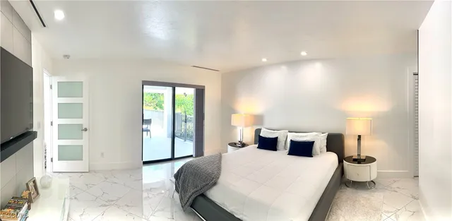 a bedroom with a large bed and wooden floor