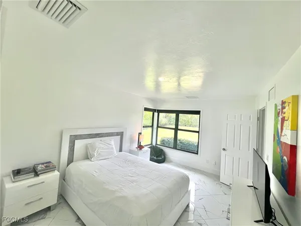 a bedroom with a large bed and a window