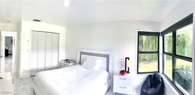 a bedroom with a bed and a large window