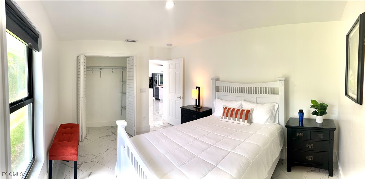 1919 Countess Court Naples, FL 34110 - Photo 19 of 30 a bedroom with a bed and a chair