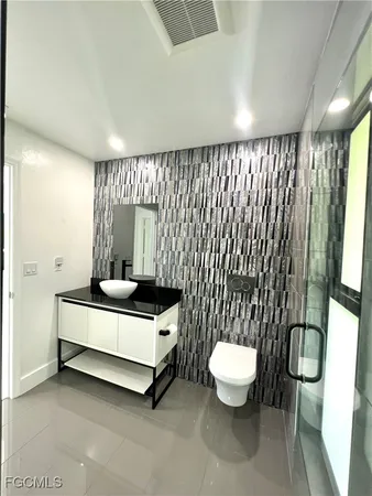 a spacious bathroom with a toilet sink and a mirror
