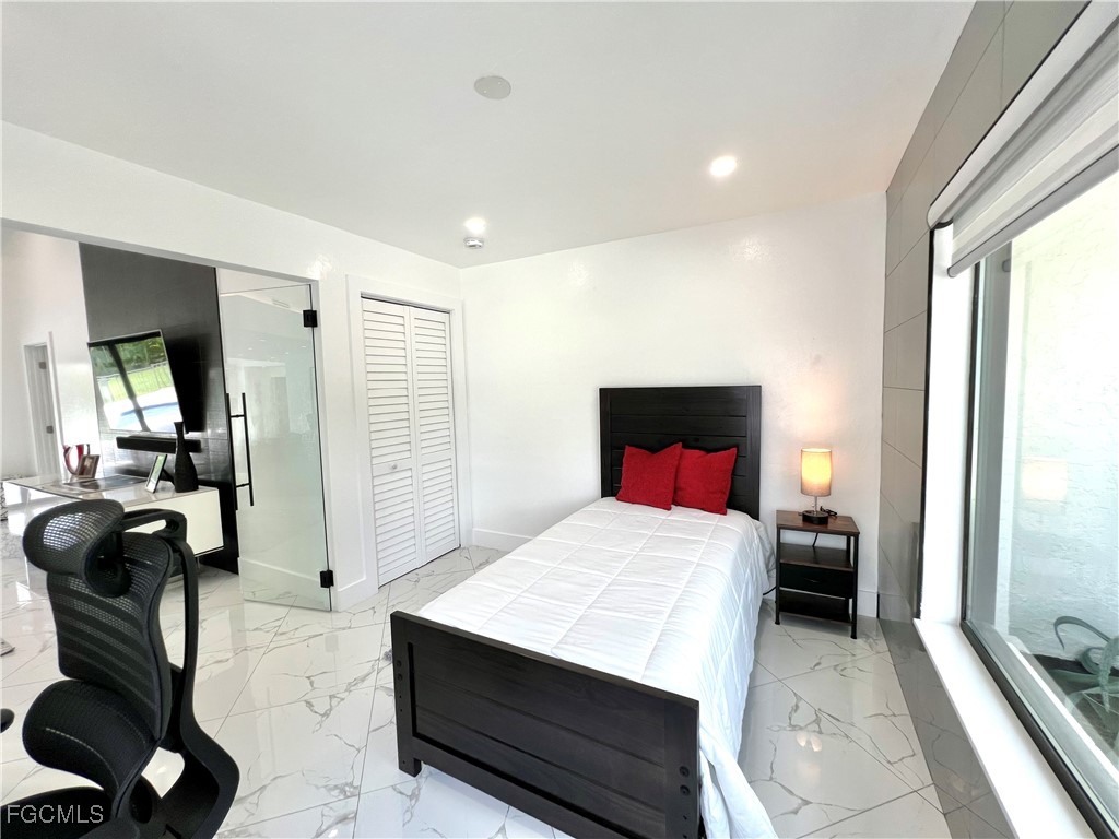 1919 Countess Court Naples, FL 34110 - Photo 24 of 30 a bedroom with a bed and a couch