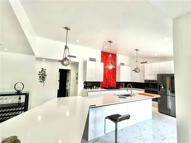 a kitchen with stainless steel appliances kitchen island granite countertop a sink and cabinets