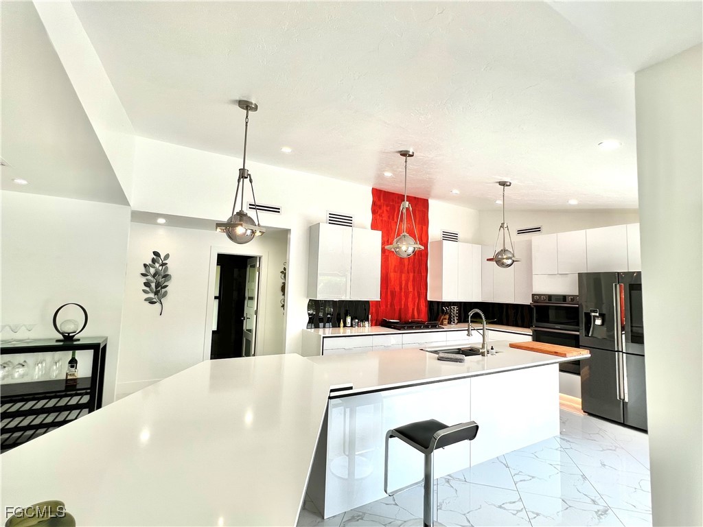 1919 Countess Court Naples, FL 34110 - Photo 4 of 30 a kitchen with stainless steel appliances kitchen island granite countertop a sink and cabinets