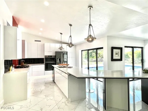 a kitchen with stainless steel appliances granite countertop a stove a sink and a refrigerator