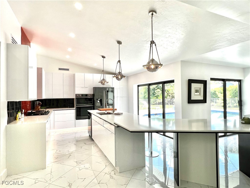 1919 Countess Court Naples, FL 34110 - Photo 5 of 30 a kitchen with stainless steel appliances granite countertop a stove a sink and a refrigerator