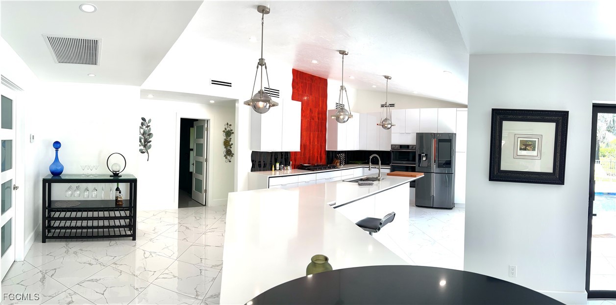 1919 Countess Court Naples, FL 34110 - Photo 7 of 30 a kitchen with a refrigerator and a stove top oven