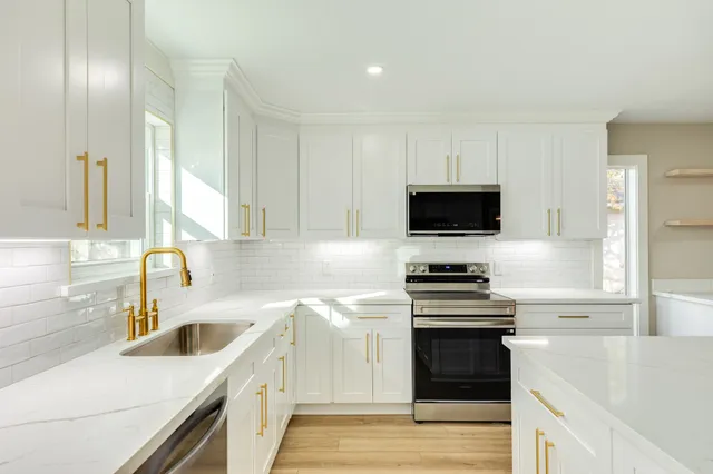 a kitchen with stainless steel appliances a stove sink and microwave