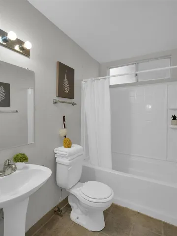 a white toilet sitting next to a bathroom sink and tub