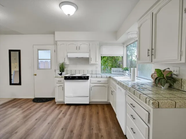 a kitchen with a white cabinets and window