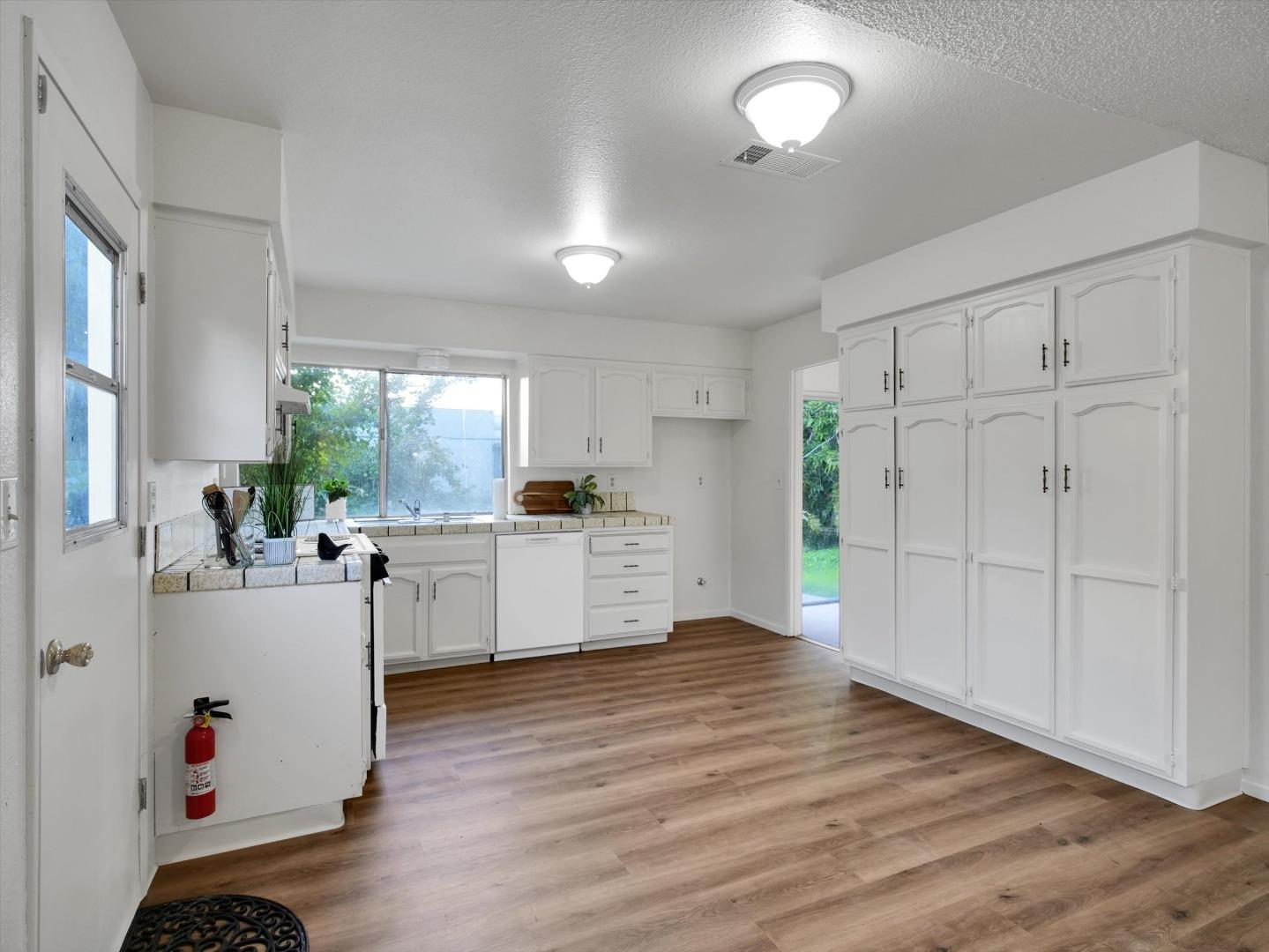 3559 Vernal Avenue Merced, CA 95340 - Photo 6 of 25 a kitchen with white cabinets and wooden floor