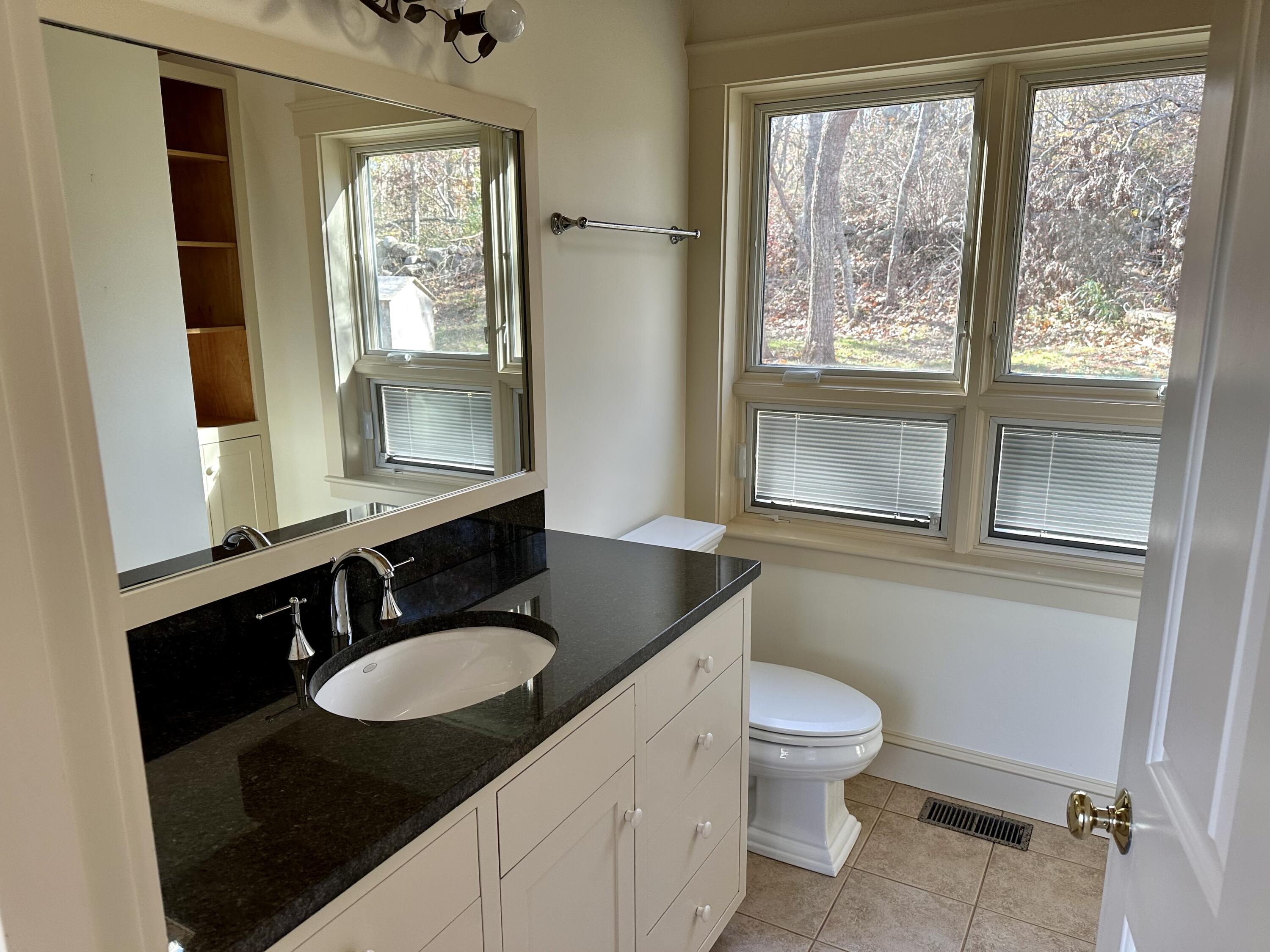 8 Harpoon Hollow Road Aquinnah, MA 02535 - Photo 12 of 29 a bathroom with a granite countertop sink toilet a mirror and a window