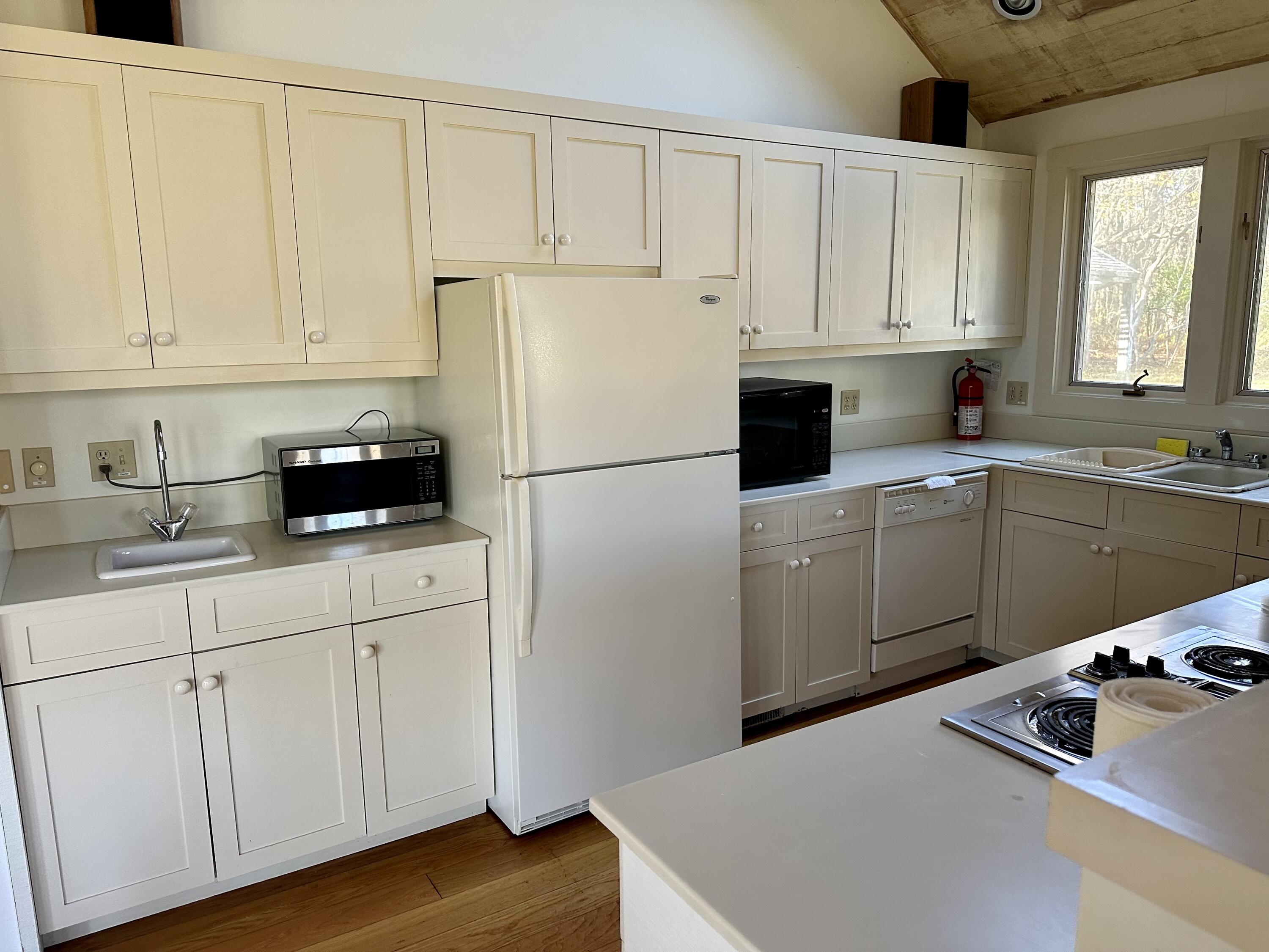 8 Harpoon Hollow Road Aquinnah, MA 02535 - Photo 4 of 29 a kitchen with white cabinets and white appliances
