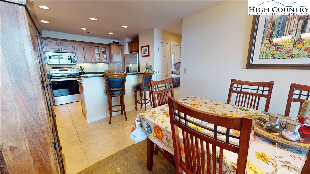 200 Trails End, Unit 36A Sugar Mountain, NC 28604 - Photo 13 of 35 a kitchen view with stainless steel appliances wooden floor dining table and chairs