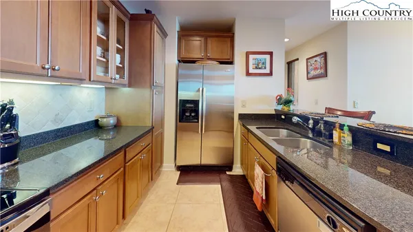 a kitchen with stainless steel appliances granite countertop a sink a stove and a refrigerator