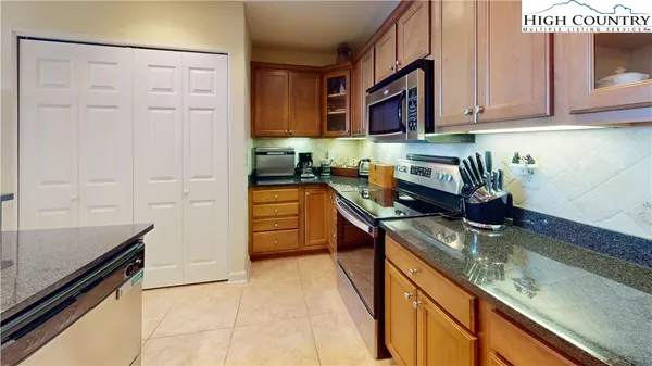 a kitchen with stainless steel appliances granite countertop a sink stove and cabinets