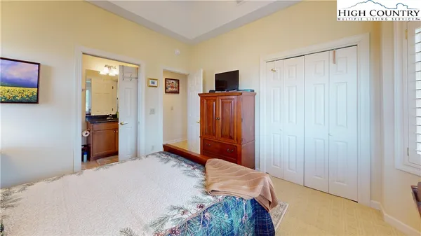 a bedroom with a bed and a flat tv screen