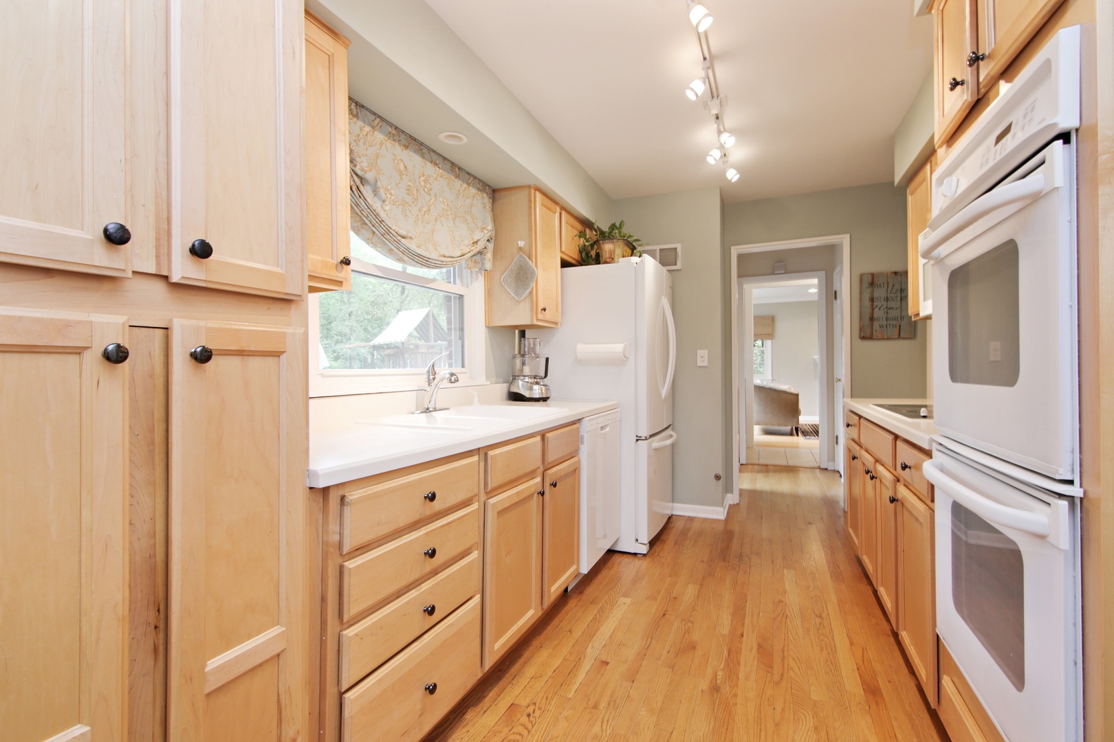 1422 Hackberry Road Deerfield, IL 60015 - Photo 5 of 12 a kitchen with white cabinets and wooden floor