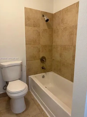 a white toilet sitting next to a bath tub