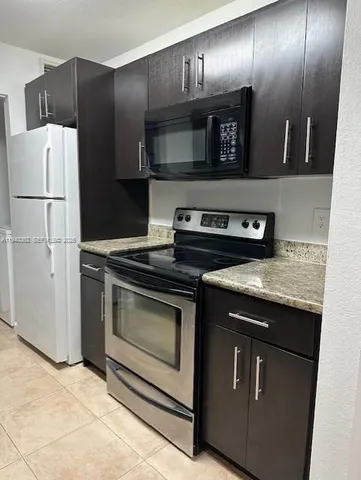 a kitchen with granite countertop stainless steel appliances and wooden cabinets