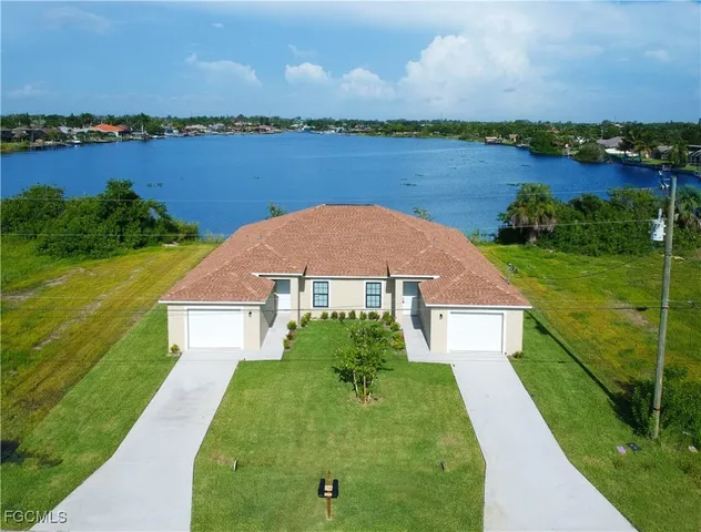 a aerial view of a house with a yard and lake view