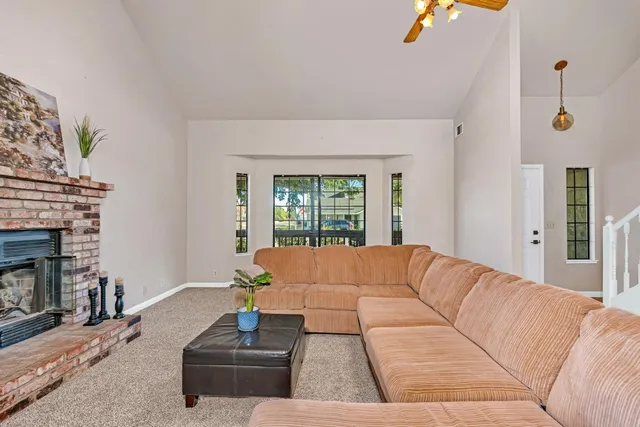 a living room with a couch a fireplace and a window