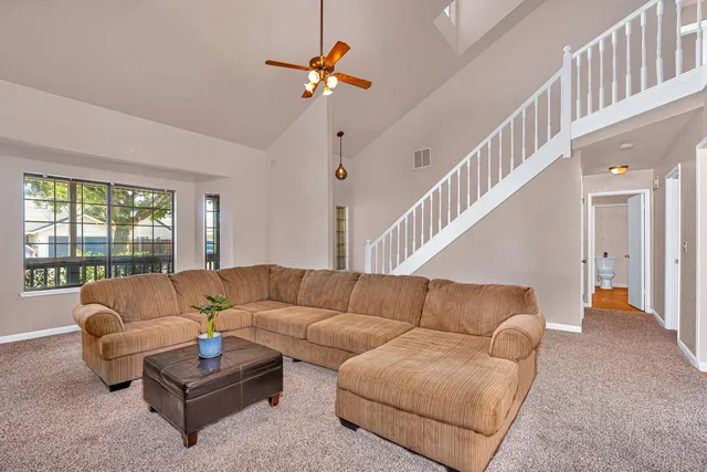 a living room with furniture and a ceiling fan
