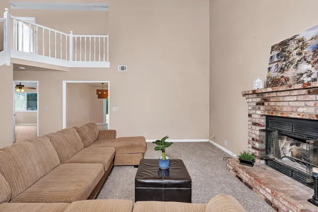 a living room with furniture a fireplace and a chandelier