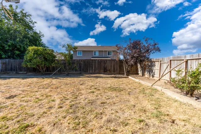 a backyard of a house with wooden fence