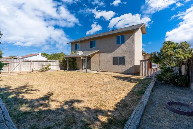 a view of a white house with a yard