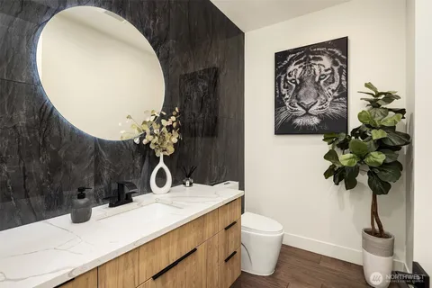a bathroom with a toilet a sink and mirror