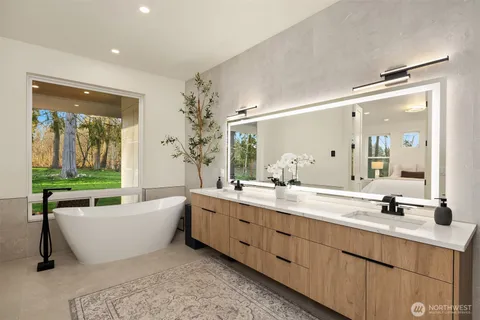 a bathroom with a large tub sink and mirror
