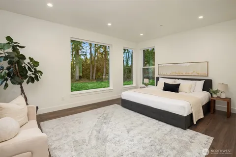 a bedroom with a large bed and a potted plant