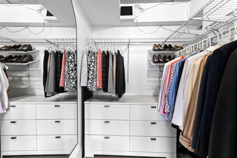 a view of walk in closet with clothes and shoes