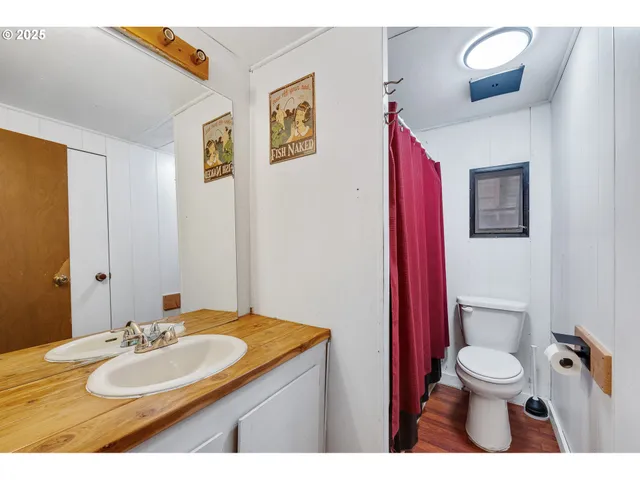 a bathroom with a granite countertop sink toilet a mirror and shower