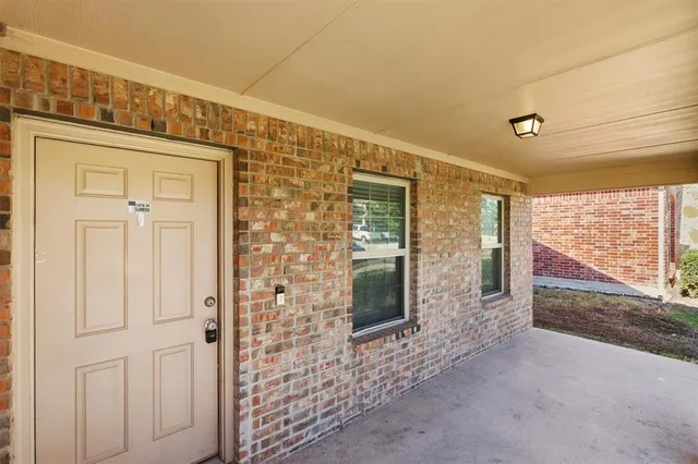 an empty room with windows and fireplace