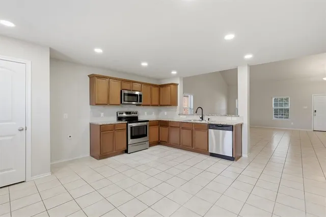 a kitchen with stainless steel appliances granite countertop a stove a sink and a refrigerator