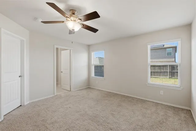 a view of a big room with chandelier fan and windows