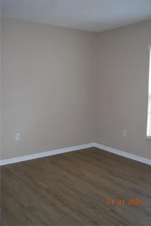 a view of an empty room with wooden floor