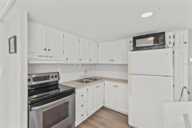 a kitchen with white cabinets and white appliances