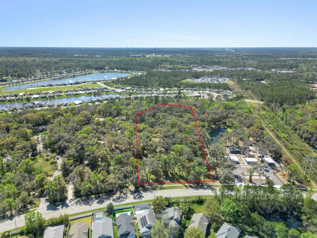an aerial view of residential houses with outdoor space and trees
