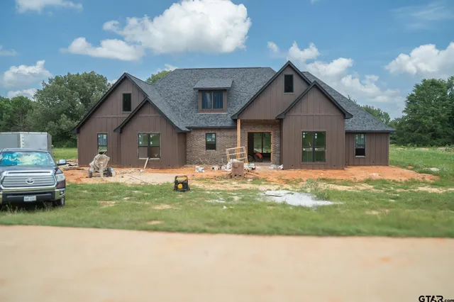 a front view of a house with a garden and yard