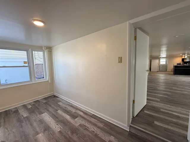 a view of a room with wooden floor and window