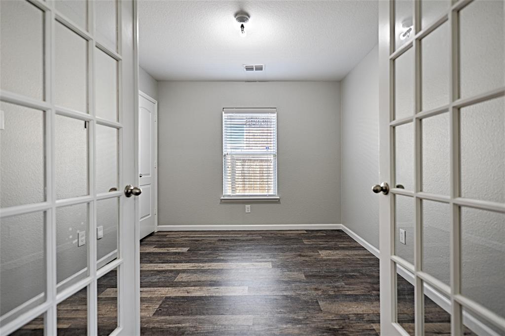 129 Lamont Road Anna, TX 75409 - Photo 6 of 40 a view of an empty room with wooden floor and a window